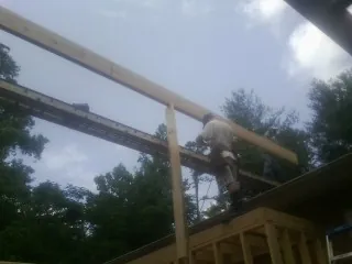 Carpenter setting a ridge beam over a new addition frame — Ice Dam Removal by Roofing Brothers in Crystal Springs
